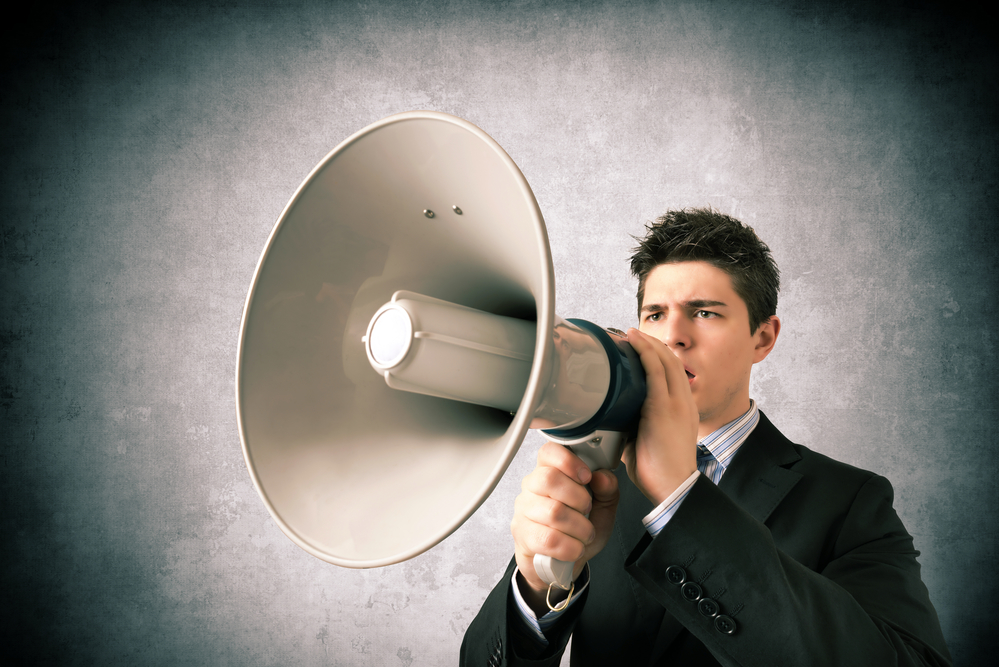 Young Business Man Speaking With A Megaphone